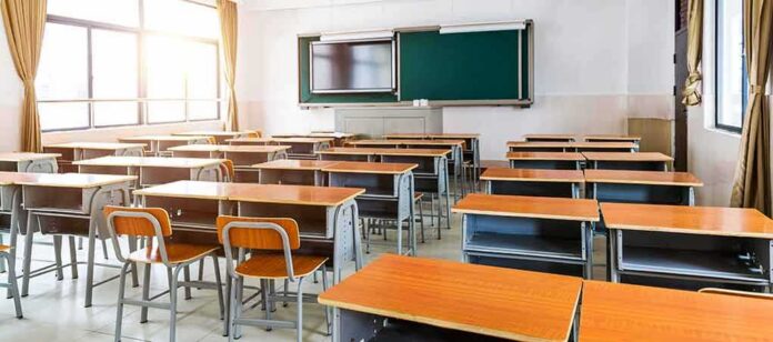 Empty classroom with rows of desks and a chalkboard