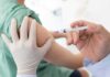 Healthcare worker giving an intramuscular injection in upper arm