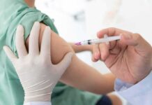 Healthcare worker giving an intramuscular injection in upper arm