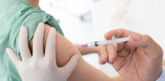 Healthcare worker giving an intramuscular injection in upper arm