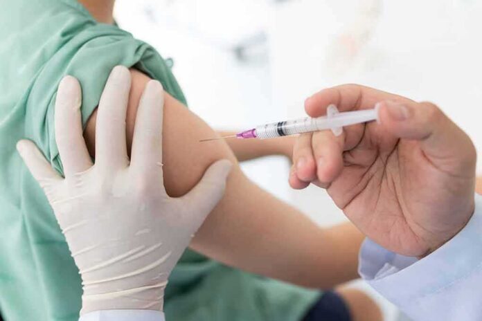 Healthcare worker giving an intramuscular injection in upper arm