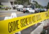 crime scene tape stretches across a blocked city street