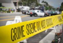 crime scene tape stretches across a blocked city street