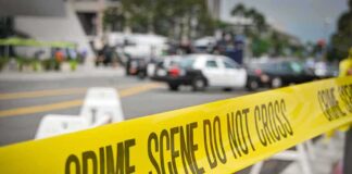 crime scene tape stretches across a blocked city street