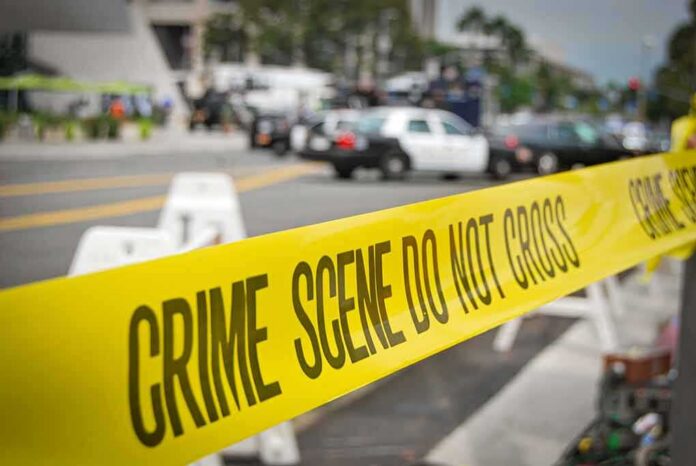 crime scene tape stretches across a blocked city street