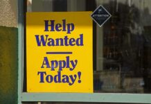 LinkedIn Under Fire: Ghost Jobs Exposed Help Wanted sign in a shop window