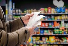 Hands holding receipts in a grocery aisle