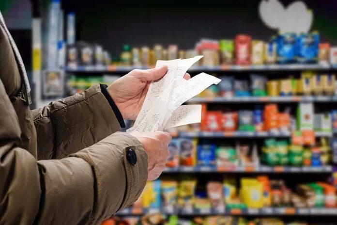 shutterstock_1980000383 Hands holding receipts in a grocery aisle