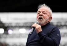 Elderly man speaking into a microphone on stage