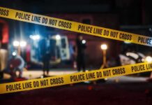 Police tape cordons off a dimly lit crime scene