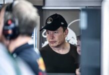 man in black cap looks ahead indoors