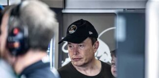 man in black cap looks ahead indoors