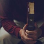 Texas Uproar: ‘Christian Who Hates Christianity’ Person holding a closed Bible while seated
