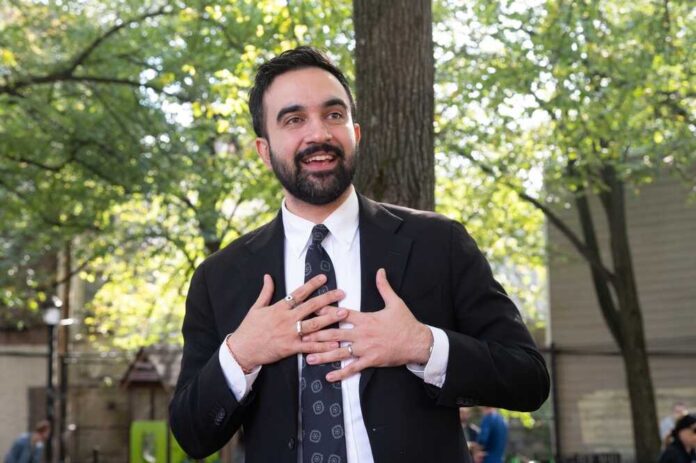 Man in suit speaking with hands on chest outdoors