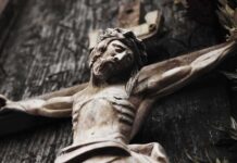Silent Spectators? Catholics Push Back Wooden crucifix of a bearded figure with outstretched arms