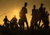 Silhouettes of people walking at sunset