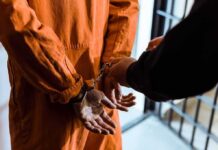 Encrypted App, Horrifying Send — Prison Prisoner in orange jumpsuit handcuffed by officer