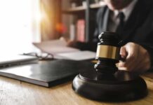 Prosecutor Undercuts ‘Armed Attack’ Hype Judge's gavel on desk with person reading documents in background