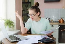 Bank Report: Parents Bankroll Grown Kids Young woman with glasses frustrated at laptop while holding bills