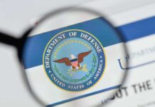 White House Meeting, Then Boom—He’s Out magnifying glass focusing on U.S. Department of Defense seal