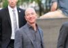 Shock Win: Bezos Grabs Mars Network bald man in a gray suit smiling outdoors