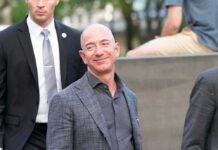 Shock Win: Bezos Grabs Mars Network bald man in a gray suit smiling outdoors