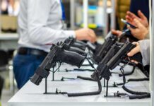 Justice Department Torpedoes Handgun Age Rule Handguns displayed on stands at a trade show counter