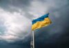 First-In-World Howitzer Lands In Ukraine Ukrainian flag waving against a stormy sky