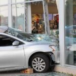 Silver car crashed into storefront window