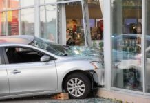 Silver car crashed into storefront window