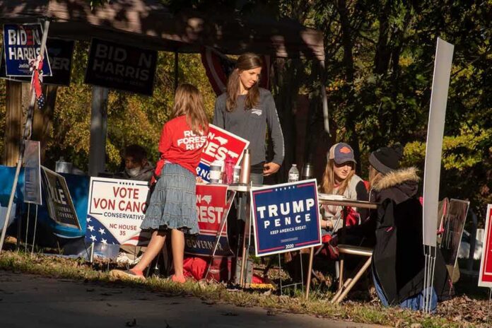shutterstock_1846845484 People at a campaign booth with political signs outdoors