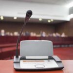 Senators Kill Ban—Predators Stay Eligible Microphone on a podium in a courtroom