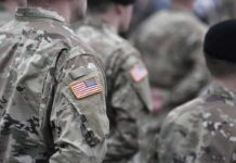 Soldiers in camouflage uniforms with U.S. flag patches