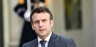 man in a dark suit speaking outdoors