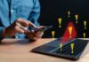 Ad-Tech Turned Bases Into Target Maps Person using smartphone near laptop with warning icons