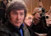 Man surrounded by reporters with cameras and phones