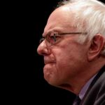 Superintelligence Ban? Sanders Lights the Fuse Bernie Sanders in profile wearing glasses against a black background