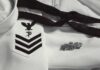 Navy dress uniform with rank chevrons and insignia