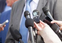 New Law Lets Nonprofits Muzzle Watchdogs Microphones held toward a person in a suit
