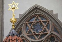 Synagogue Fights 100-Yard Disarm Zone Star of David atop synagogue roof with stained glass window