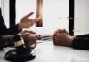 Sanity Fight Derails Terror Case – For Now Lawyer consulting client at desk with gavel and scales