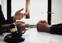 Sanity Fight Derails Terror Case – For Now Lawyer consulting client at desk with gavel and scales