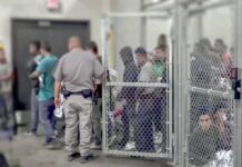 Illegal Presence? Homan Drops Deportation Reality Check People standing inside chain-link holding area with an officer nearby
