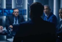 Hunter Twist: Top FBI Officials Caught In Laptop Whiplash Business professionals in a dim conference room meeting