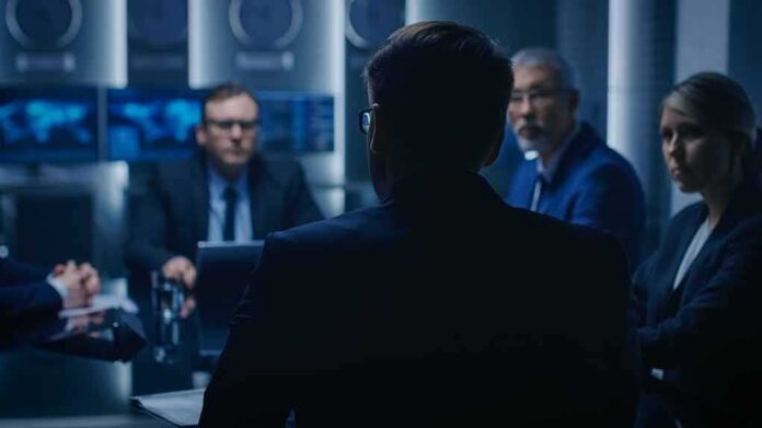 Business professionals in a dim conference room meeting