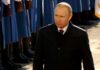 Russia’s War Machine Eats the Economy Vladimir Putin walking past a guard of honor