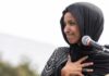 Denaturalization Push Could Blow Up Omar’s Seat Ilhan Omar speaking at a microphone with hand on chest