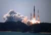 Rocket lifts off from coastal launch site with smoke and flames