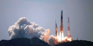 Rocket lifts off from coastal launch site with smoke and flames