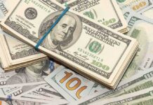 Stack of US hundred-dollar bills bound with a blue band